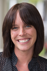 A woman smiles while posing for a headshot.